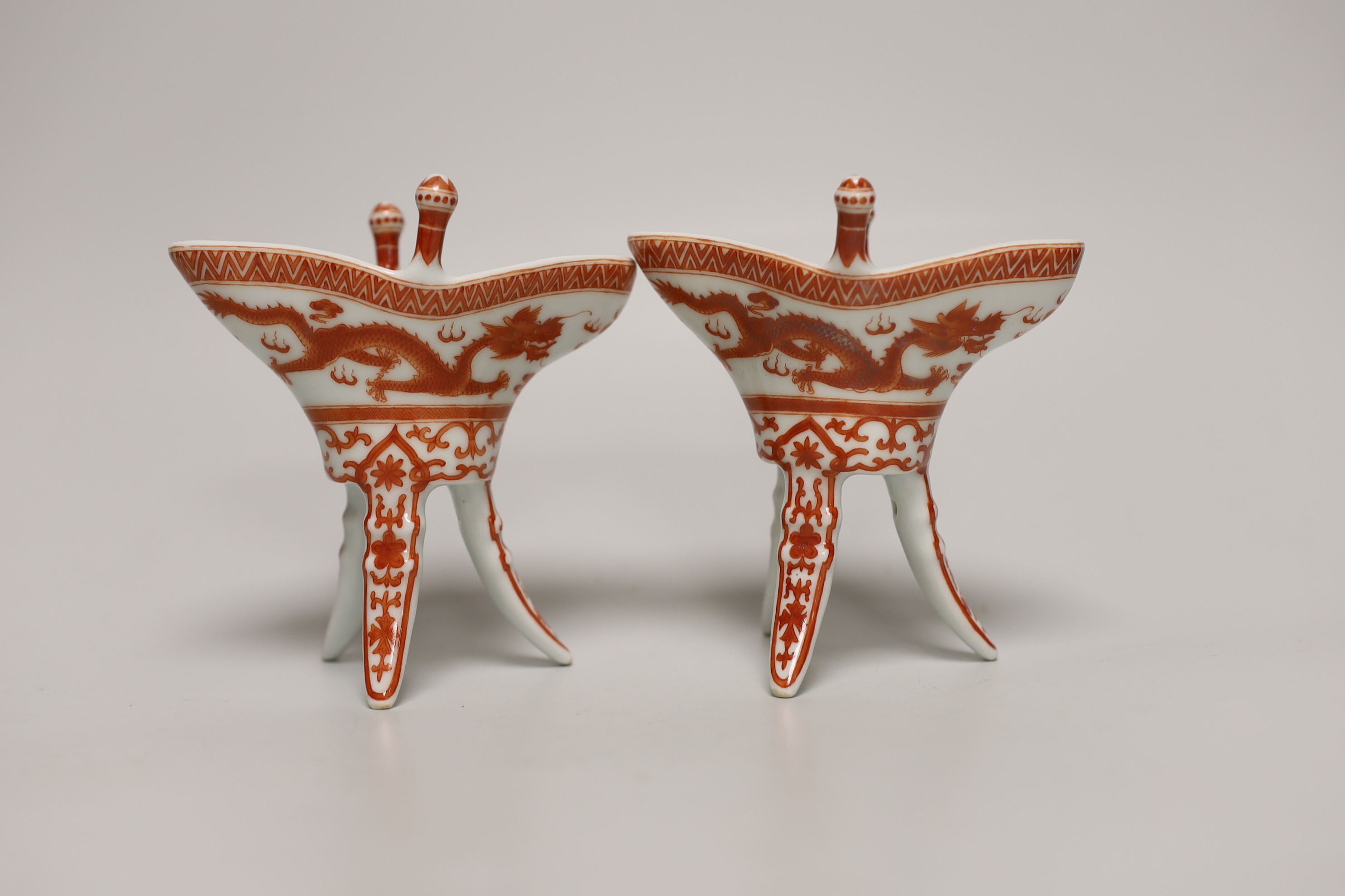 A pair of Chinese iron-red dragon vessels, jue, (boxed), 10cm high
